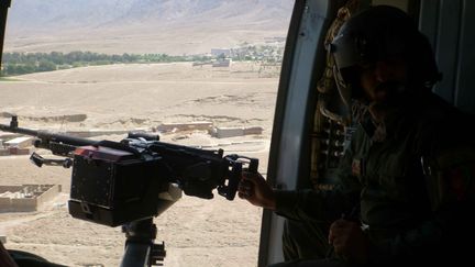 Depuis un hélicoptère, un soldat afghan scrute la province de&nbsp;Nangarhar, le 8 août 2016, où&nbsp;le chef de l'Etat islamique,&nbsp;Hafez Saïf, a été tué.&nbsp; (ZABIHULLAH GHAZI / AFP)