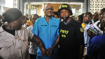 Charles Sirleaf (centre), ancien gouverneur adjoint de la Banque centrale du Libéria, fils de l'ancienne présidente de la Libéria, Ellen Johnson Sirleaf, se tient devant le tribunal municipal de Monrovia, le 4 mars 2019. Il a été inculpé de&nbsp;"complot criminel" et de "sabotage économique"&nbsp;dans une affaire&nbsp;de billets entrés dans le pays entre 2016 et 2018. (ZOOM DOSSO / AFP)