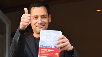 Lauréat du Goncourt, l'auteur français Jean-Baptiste Andrea pose avec son livre "Veiller sur elle" lors de la remise du prix au restaurant Drouant à Paris, le 7 novembre 2023. (BERTRAND GUAY / AFP)