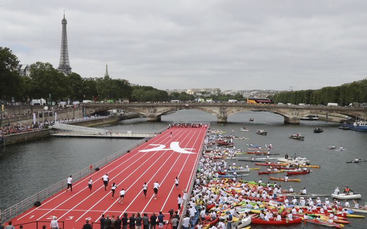 Paris a installé sur la Seine, le 23 juin 2017, une piste d'athlétisme pour&nbsp;célébrer la journée qui marque la création du Comité international olympique par Pierre de Coubertin le 23 juin 1894. (JACQUES DEMARTHON / AFP)