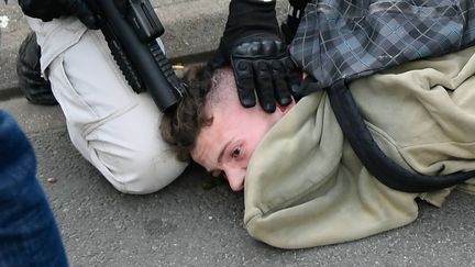 Un policier interpelle un manifestant lors d'un rassemblement des "gilets jaunes" au Mans, le 23 mars 2019, et son LBD touche le crâne du jeune homme. (MAXPPP)