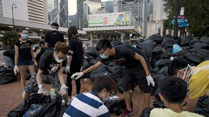 Des manifestants ramassent des bouteilles &agrave; recycler, le 1er octobre 2014, &agrave; Hong Kong. (TYRONE SIU / REUTERS)