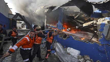 Des pompiers à Gaza tentent d'éteindre un incendie après une frappe aérienne, le 17 mai 2021.&nbsp; (MAHMUD HAMS / AFP)