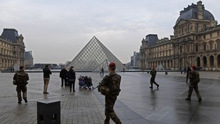 Des militaires de l'opération Sentinelle devant le musée du Louvre, à Paris, le 16 février 2017.&nbsp; (CHRISTOPHE ARCHAMBAULT / AFP)