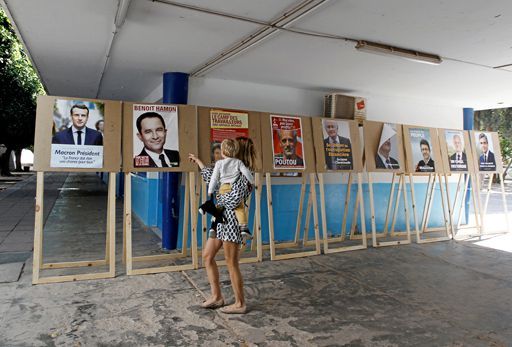 Le 23 avril 2017, une résidente française montre à son enfant des panneaux électoraux de la présidentielle dans un bureau de vote à Tunis. (REUTERS - Zoubeir Souissi)