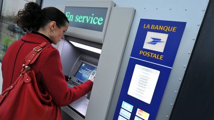 Une cliente retire de l'argent &agrave; un distributeur de la Banque postale &agrave; Caen, le 22 d&eacute;cembre 2008. (MYCHELE DANIAU / AFP)