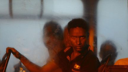 Un migrant secouru au large de Malte est embarqu&eacute; dans un bus de la police maltaise &agrave; La Valette (Malte), le 10 juillet 2013. (DARRIN ZAMMIT LUPI / REUTERS)