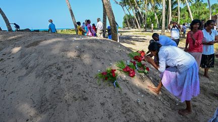 Une femme prie sur une fosse commune près de la plage à Peraliya (Sri Lanka). (ISHARA S. KODIKARA / AFP)