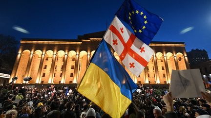 Les drapeaux ukrainien, géorgien et européen brandis à Tbilissi (Géorgie), le 8 mars 2023. (VANO SHLAMOV / AFP)