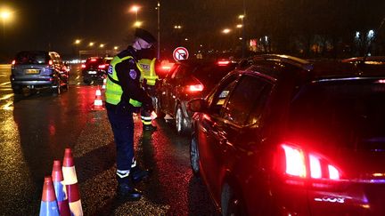 Un policier contrôle un automobiliste, le 31 janvier 2021, au péage du Buchelay dans les Yvelines, durant le couvre-feu. (CHRISTOPHE ARCHAMBAULT / AFP)