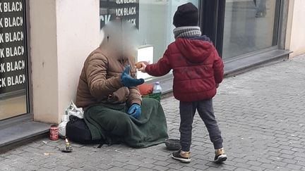 Lucas en train d'offrir une viennoiserie à un sans-abris dans une rue d'Amiens (Somme). (FACEBOOK)