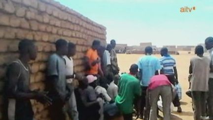 De jeunes Maliens se protègent lors de combats à Gao, le 24 mars 2013. (AITV)