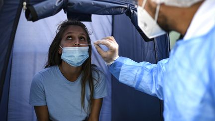 Une femme réalise un test PCR de dépistage au Covid-19, à Paris, le 4 septembre 2020. (CHRISTOPHE ARCHAMBAULT / AFP)