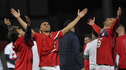 Zeki Celik (au centre) et Yusuf Yazici (à droite) fêtent le titre du LOSC, le 23 mai 2021 à Angers. (LOIC VENANCE / AFP)