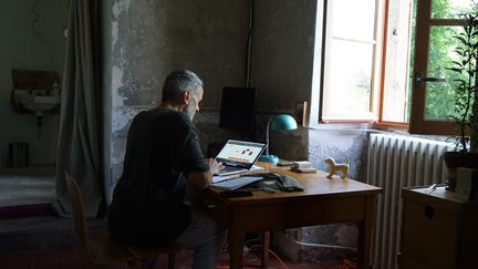 Un homme travaille depuis sa maison de campagne à Lormes&nbsp;(Nièvre), le 22 juillet 2021. (MYRIAM TIRLER / HANS LUCAS / AFP)