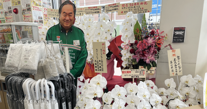 Inside the very first konbini, flowers commemorate 50 years of the Japanese convenience store and surround a model of the first owner, 77-year-old Kenji Yamamoto.  (KARYN NISHIMURA / RADIO FRANCE)