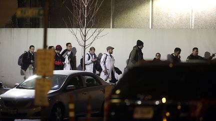 Un officier de police escorte&nbsp;des travailleurs de l'hôpital Mercy devant l'entrée principale après qu'un homme armé ait tiré sur plusieurs personnes le 19 novembre 2018 à Chicago, dans l'Illinois. (JOSHUA LOTT / GETTY IMAGES NORTH AMERICA / AFP)