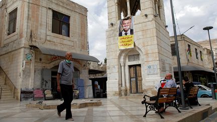 Une banderole s'en prenant à Emmanuel Macron déployée sur une place de Naplouse, en Cisjordanie occupée, le 25 octobre 2020. (MOHAMAD TOROKMAN / REUTERS)