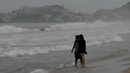 Des habitants sur une plage d'Acapulco (Mexique), le 24 octobre 2023, avant le passage de l'ouragan Otis. (FRANCISCO ROBLES / AFP)