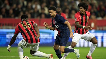 Warren Zaire-Emery au milieu de deux défenseurs niçois lors de la 7e journée de Ligue 1, le 6 octobre 2024, à l'Allianz Riviera. (VALERY HACHE / AFP)