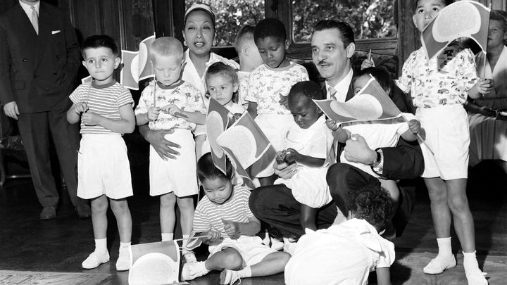 Joséphine Baker et dix de ses enfants adoptifs sont reçus à la mairie de Paris par Jacques Dursort, vice-président du conseil municipal de Paris, le 7 août 1959 (AFP)