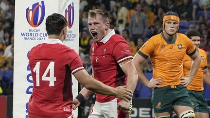 La joie des Gallois Nick Tompkins et Louis Rees-Zammit contraste avec la consternation des Australiens, le 24 septembre 2023 à Lyon. Battue, l'Australie prendra ensuite la porte dès la phase de groupes pour la première fois de son histoire. (LAURENT CIPRIANI / AP)