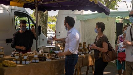 Le candidat RN aux régionales en Bourgogne-Franche-Comté, Julien Odoul, sur un marché de Montceau-les-Mines (Saône-et-Loire), le 12 juin 2021. (FLORIAN JANNOT-CAEILLETE / HANS LUCAS / AFP)