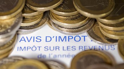 Un avis d'imposition sur le revenu et des pi&egrave;ces de 1 euro photo r&eacute;alis&eacute;e le 7 septembre 2012. (JOEL SAGET / AFP)