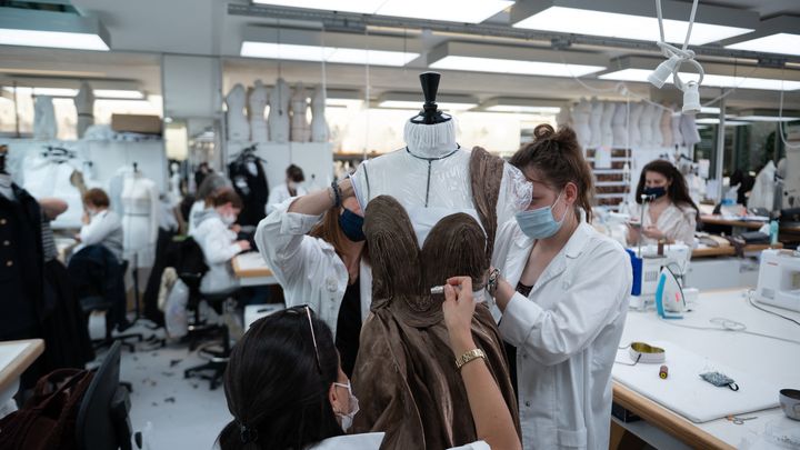 Des employées travaillent sur la collection Haute Couture au siège de Christian Dior à Paris, le 3 juillet 2021. (MARTIN BUREAU / AFP)