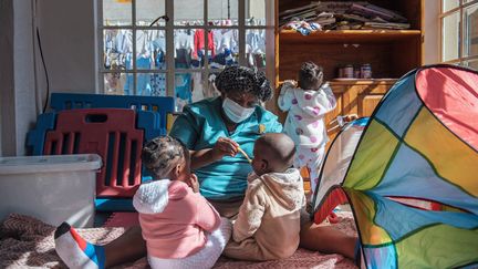 Une infirmière donne à manger à des enfants abandonnés dans un orphelinat de Johannesburg le 27 juin 2019.
 (MICHELE SPATARI / AFP)