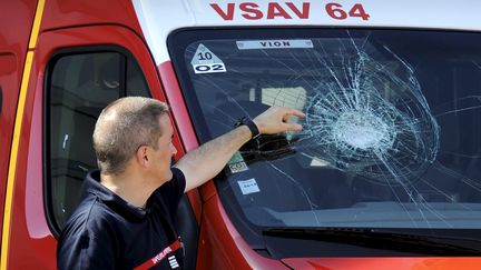 Le commandant Thierry Lasserre montre l'impact des pierres lanc&eacute;es sur le vehicule des sapeurs pompiers, le 4 ao&ucirc;t 2013 &agrave; Toulouse (Haute-Garonne). (XAVIER DE FENOYL / MAXPPP)