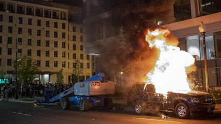 Une voiture enflammée à Washington (Etats-Unis), pendant des émeutes liées à la mort de George Floyd, le 30 mai 2020. (ERIC BARADAT / AFP)