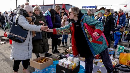 Des volontaires distribuent de la nourriture et des boissons chaudes aux Ukrainiens qui franchissent la frontière polonaise, pour fuir la guerre avec la Russie. (DOMINIKA ZARZYCKA / NURPHOTO VIA AFP)