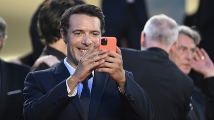 Pour son&nbsp;dernier-né "Mascarade", Nicolas Bedos brave l'interdit du téléphone portable sur le tapis rouge. L'année dernière, il avait présenté "OSS 117 : Alerte rouge en Afrique noire".&nbsp; (GARETH CATTERMOLE / GETTY IMAGES EUROPE)