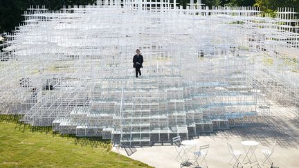 L'architecte japonais Sou Fujimoto pose assis sur sa structure install&eacute;e &agrave; la Serpentine Gallery &agrave; Londres (Royaume-Uni), le 4 juin 2013. (BEN STANSALL / AFP)