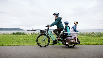 Un vélo cargo familial à assistance électrique, un mode de transport qui séduit les familles pour les transports au quotidien. (Illustration) (RYANJLANE / E+ / GETTY IMAGES)