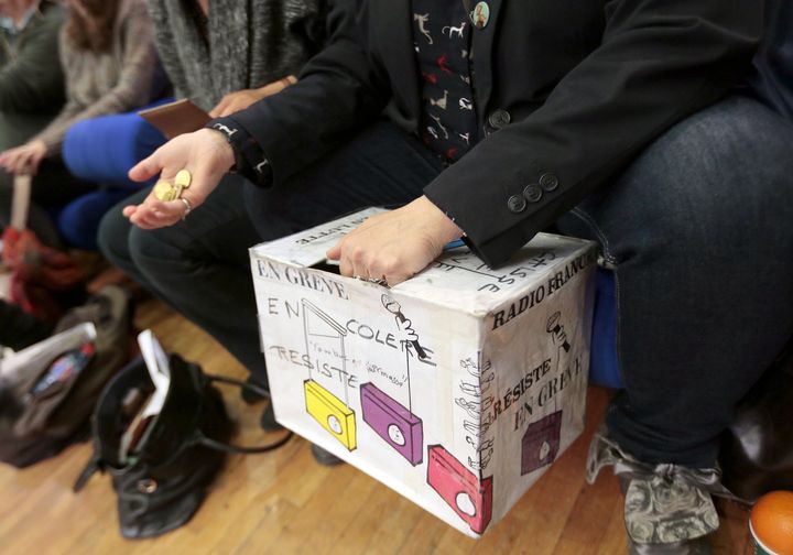 Un salari&eacute; gr&eacute;viste de Radio France collecte de l'argent dans la caisse de gr&egrave;ve, le 3 avril 2015 &agrave; la Maison de la radio &agrave; Paris, lors d'une assembl&eacute;e g&eacute;n&eacute;rale. (JACQUES DEMARTHON / AFP)