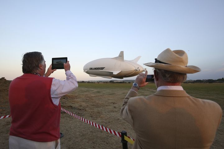 Des spectateurs découvrent l'Airlander 10, mercredi 17 août 2016 près de Bedford (Royaume-Uni), qui réalise le premier vol d'une longue série d'essais. (JUSTIN TALLIS / AFP)