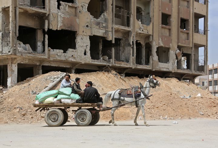 Des hommes se déplacent à bord d'une charrette dans une rue de Douma (Syrie), fief rebelle de la Ghouta orientale repris par l'armée syrienne, le 17 avril 2018.&nbsp; (AFP)