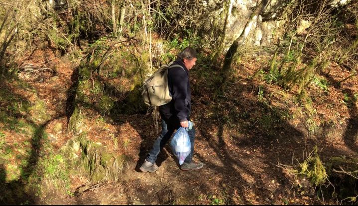 Un homme redescend ses poubelles sur le sentier de randonnée menant aux hameaux de Béroulf et Sainte-Sabine, le 4 avril 2019.&nbsp; (LOUISE HEMMERLE / FRANCE INFO)