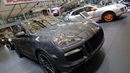 Deux top-modèles chinoises posent à côté de voitures de marque Porsche lors d'une présentation sur le tarmac de l'aéroport de la ville de Kunming, dans la province du Yunnan (sud-ouest de la Chine). (AFP /Photo Imaginechina /Yang zheng)