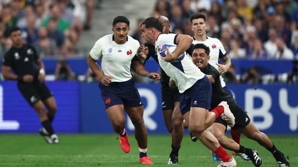 Le joueur français Damian Penaud est plaqué lors du match de la Coupe du monde de rugby 2023 entre la France et la Nouvelle-Zélande au Stade de France à Saint-Denis, le 8 septembre 2023. (FRANCK FIFE / AFP)