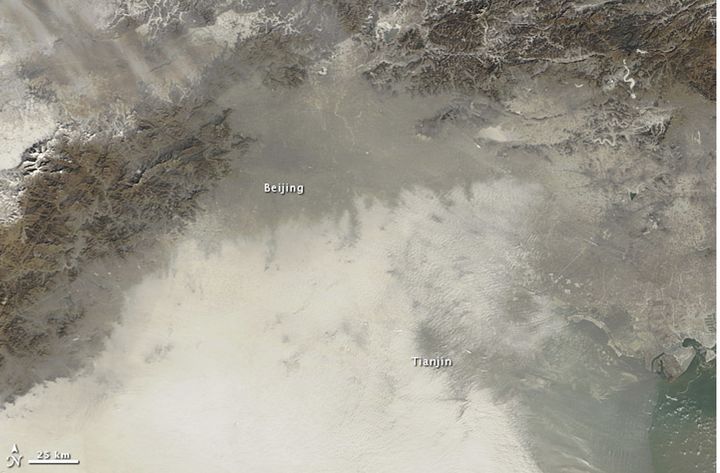 Le brouillard de particules nocives recouvrant une partie de la Chine est visible (masse blanche en bas) sur cette photo satellite de la Nasa, prise le 14 janvier 2013. (NASA / REUTERS)