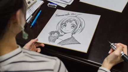 Yuki Shiwasu, l'auteure du shôjô manga "Takane &amp; Hana" réalise un dessin dédicacé pour franceinfo à Tokyo (Japon), le 3 avril 2018. (ELODIE DROUARD / FRANCEINFO)