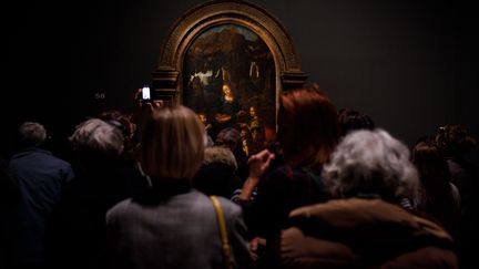 Des visiteurs admirent la "Vierge aux rochers" de Léonard de Vinci, lors de l'exposition consacrée au génie italien (18 novembre 2019) (VINCENT LOISON/SIPA)