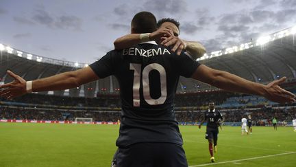 Mathieu Valbuena saute au cou de Karim Benzema, après un but marqué lors de France-Honduras&nbsp;en&nbsp;Coupe du monde, le 15 juin 2014 à Porto Alegre (Brésil). (JUAN BARRETO / AFP)