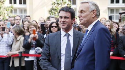 Poign&eacute;e de mains entre Manuel Valls, nouveau Premier ministre, et&nbsp;Jean-Marc Ayrault, sur le perron de Matignon, le 1er avril 2014. (PATRICK KOVARIK / AFP)