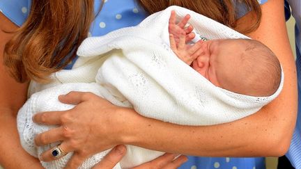 Kate Middleton tient son fils dans les bras, &agrave; la sortie de la maternit&eacute; &agrave; Londres (Royaume-Uni), le 23 juillet 2013. (JOHN STILLWELL / AFP)