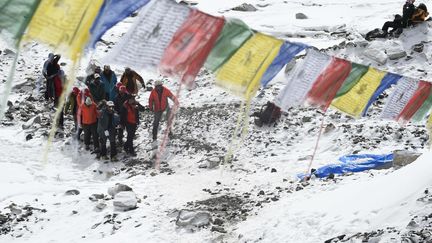 Des secouristes transportent une personne bless&eacute;e au camp de base de l'Everest, samedi 26 avril 2015. (ROBERTO SCHMIDT / AFP)