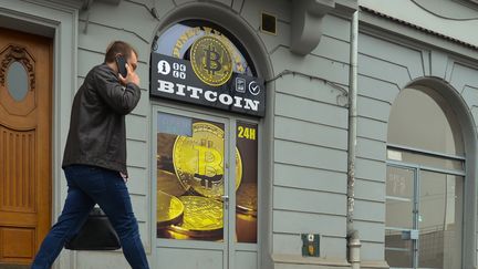 Un homme passe devant un&nbsp;local d'échange de cryptomonnaie à&nbsp;Cracovie, en Pologne, le 4 avril 2018. (ARTUR WIDAK / NURPHOTO / AFP)